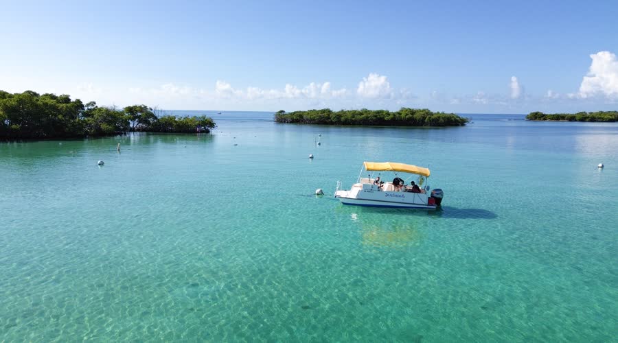 Cayo con embarcación en aguas turquesa